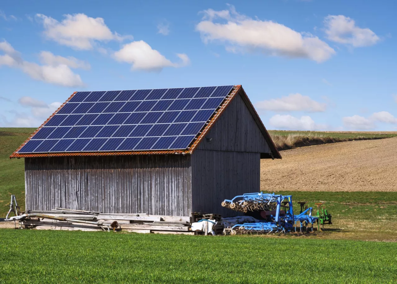 Green energy with solar collectors on the roof of an agricultural building