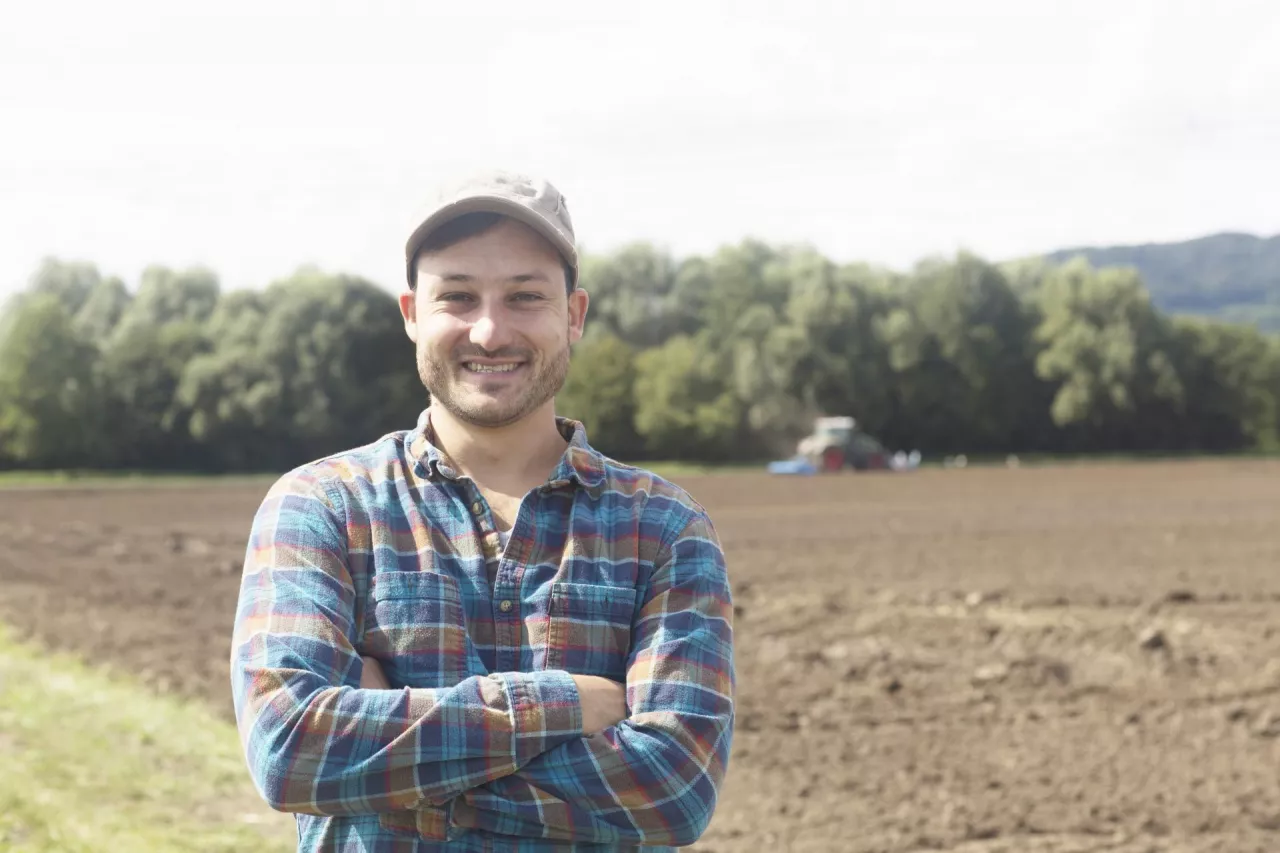 Portrait of farmer looking at camera, arms crossed smiling