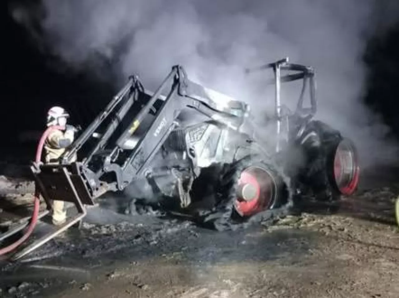 Strażacy gaszą pożar ciągnika rolniczego