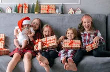 dzieci na kanapie z prezentami mikołajkowymi