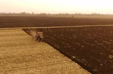 Tractor working on farm field in autumn time. Plowing ground before sowing. Agronomy, farming concept.