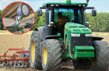 Ciągnik rolniczy w polu z dodatkowym oświetleniem roboczym.