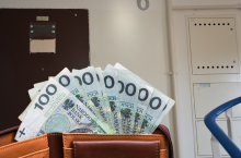 Portfel z banknotami i widok na klatkę schodową mieszkania