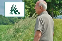 starszy rolnik patrzy na pole, w lewym górnym rogu logo KRUS