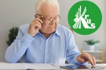 starszy mężczyzna w okularach przegląający dokumenty