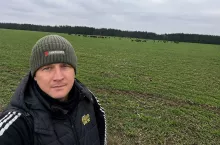 Rolnik i żubry na polu w dalszym tle
