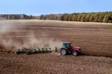 Ciągnik rolniczy pracuje na polu podczas wiosennej uprawy gleby. Zdjęcie ilustracyjne do tematów dotyczących dopłat dla rolników, wspólnej polityki rolnej, budżetu Unii Europejskiej oraz kosztów prowadzenia gospodarstw rolnych.