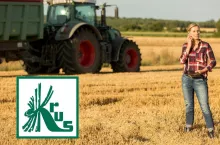 rolniczka stoi na polu i rozmawia przez telefon, z prawej u dołu logo KRUS, w oddali maszyna rolnicza