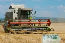 kombajn na polu, po prawej u dołu polskie banknoty