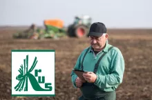rolnik na polu z telefonem w ręku, po lewej u dołu logo KRUS