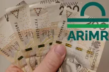 banknoty w dłoni, logo ARiMR